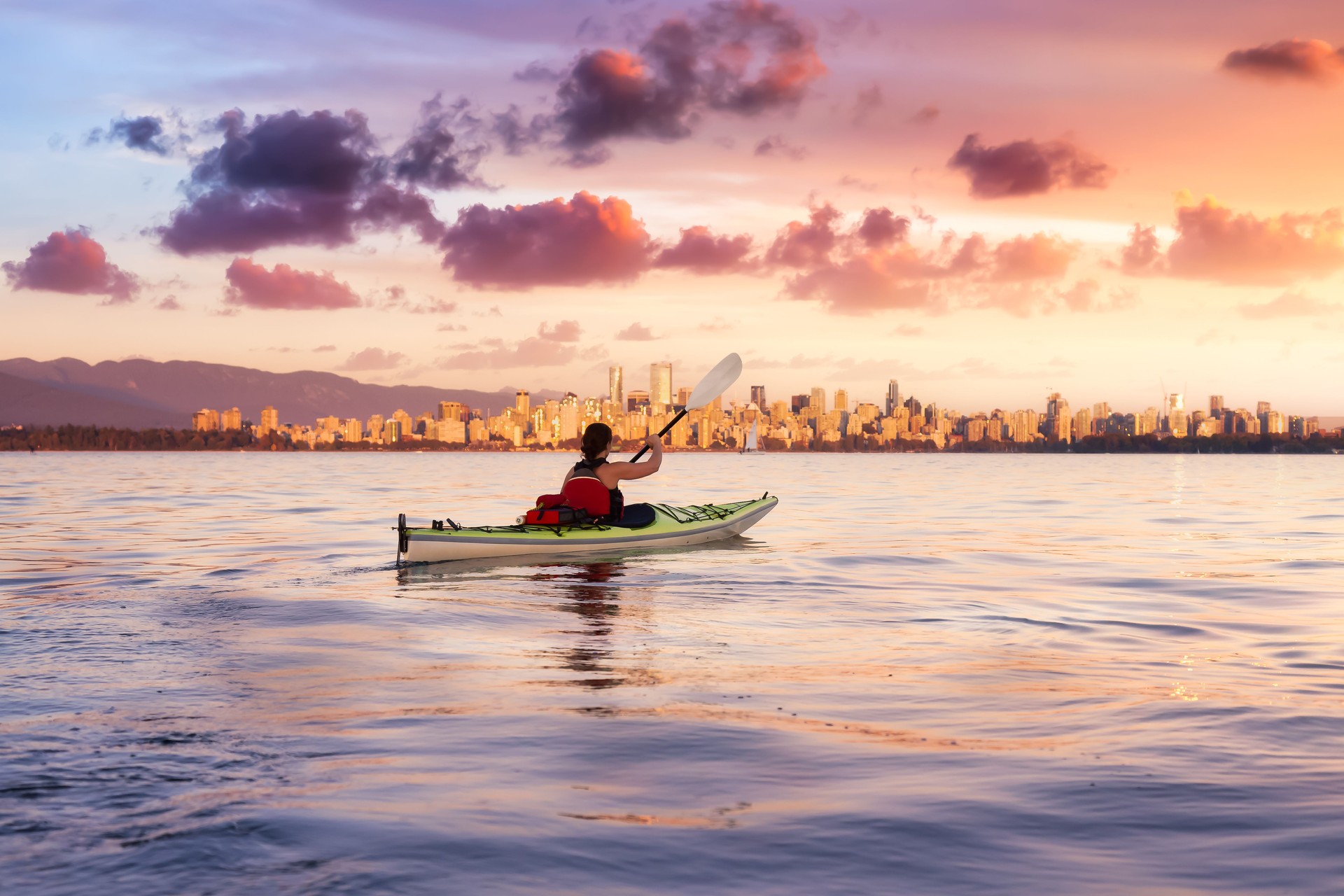 Woman on a sea kayak is paddling in the ocean